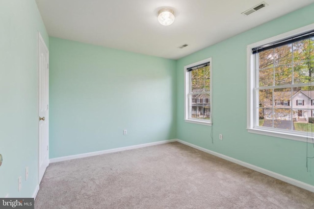carpeted spare room with baseboards and visible vents