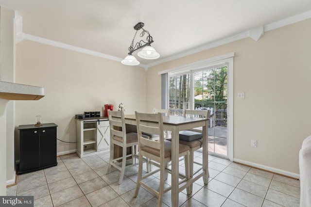 dining room featuring crown molding, baseboards, and light tile patterned floors
