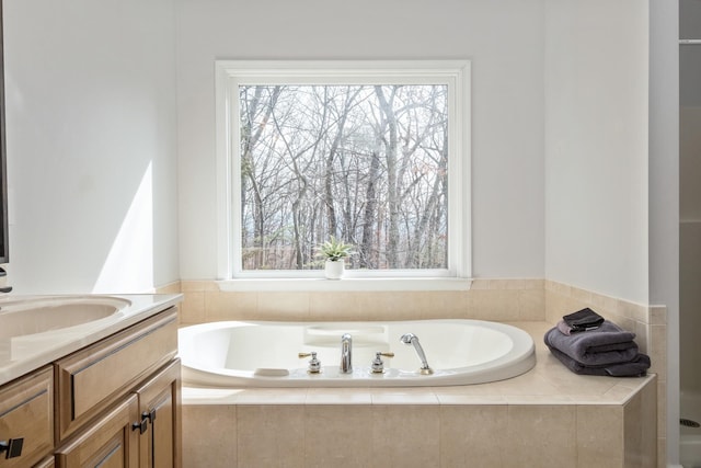 full bath featuring a garden tub and vanity