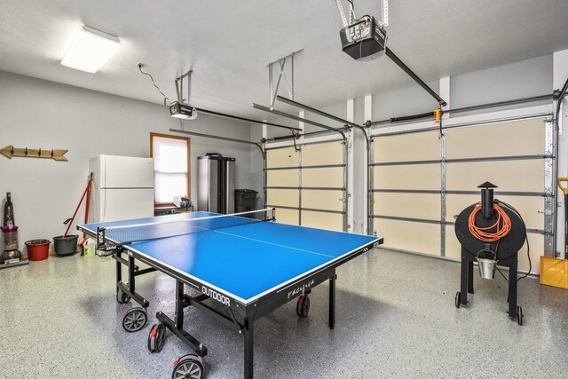 playroom with water heater, speckled floor, and a garage