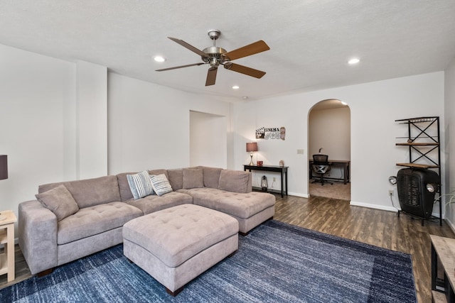 living area featuring recessed lighting, wood finished floors, arched walkways, and baseboards