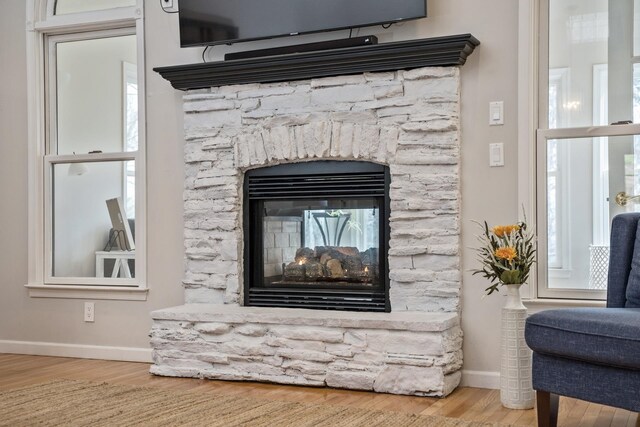 interior details with a fireplace, baseboards, and wood finished floors