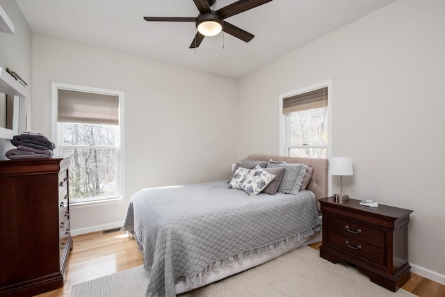 bedroom with visible vents, a ceiling fan, light wood-type flooring, and baseboards