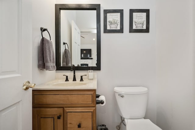 half bath featuring vanity and toilet