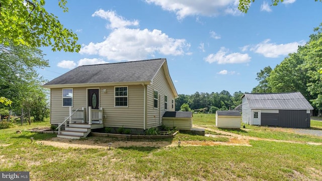 bungalow featuring a storage shed and a front lawn