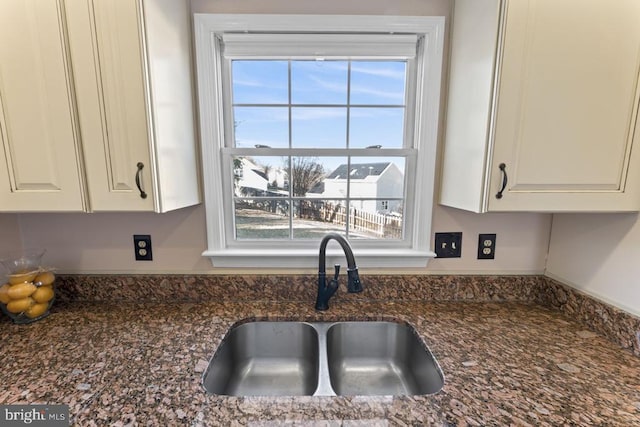 kitchen with a wealth of natural light, white cabinets, and a sink