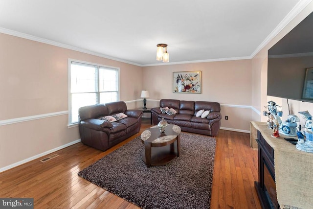 living area with visible vents, ornamental molding, baseboards, and wood-type flooring