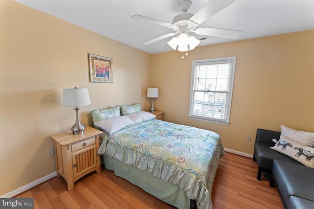 bedroom featuring light wood-style flooring, a ceiling fan, and baseboards