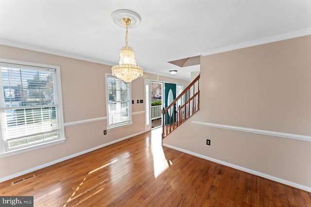 entryway featuring baseboards, visible vents, ornamental molding, stairs, and wood-type flooring