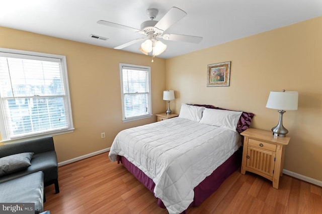 bedroom featuring a ceiling fan, baseboards, visible vents, and light wood finished floors