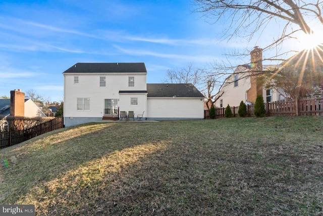 back of house featuring a patio area, a yard, and a fenced backyard