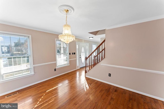 entryway featuring visible vents, stairway, wood-type flooring, crown molding, and baseboards