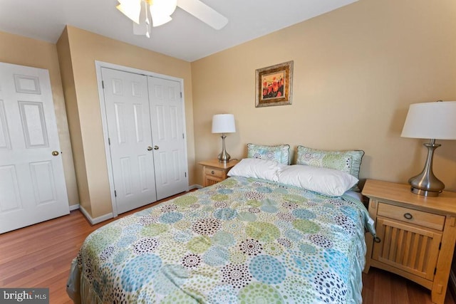 bedroom with baseboards, wood finished floors, a closet, and ceiling fan