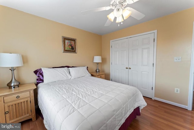 bedroom featuring ceiling fan, wood finished floors, a closet, and baseboards