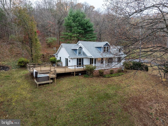 view of front of home with a front lawn, roof with shingles, a wooden deck, and covered porch