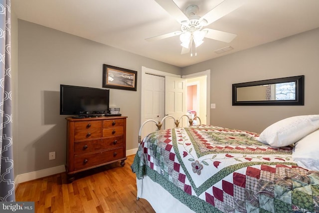 bedroom with a closet, ceiling fan, light wood-style flooring, baseboards, and visible vents