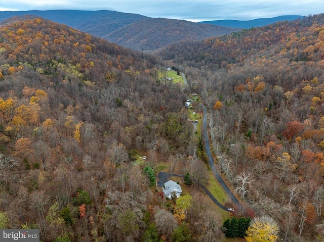 drone / aerial view featuring a mountain view and a wooded view