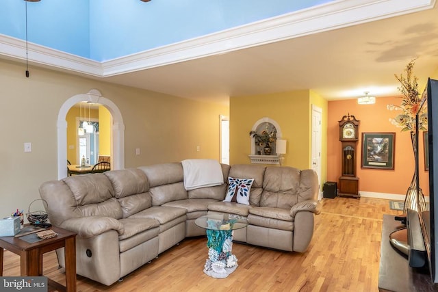 living room featuring light wood-type flooring and arched walkways