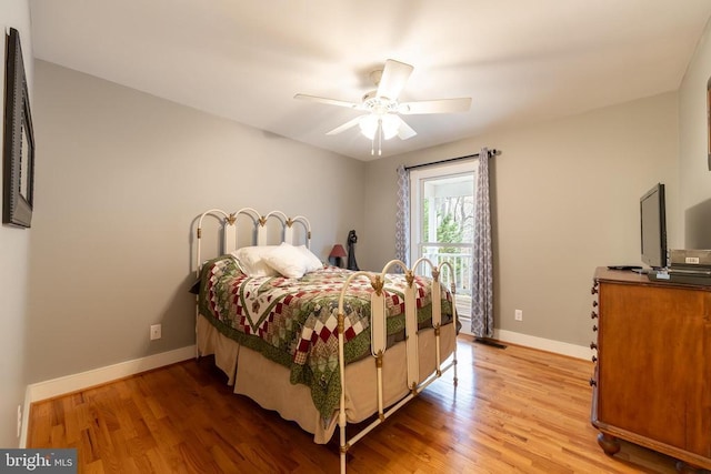 bedroom featuring light wood-style floors, visible vents, a ceiling fan, and baseboards