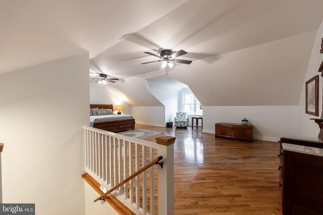 additional living space featuring wood finished floors, lofted ceiling, baseboards, and ceiling fan