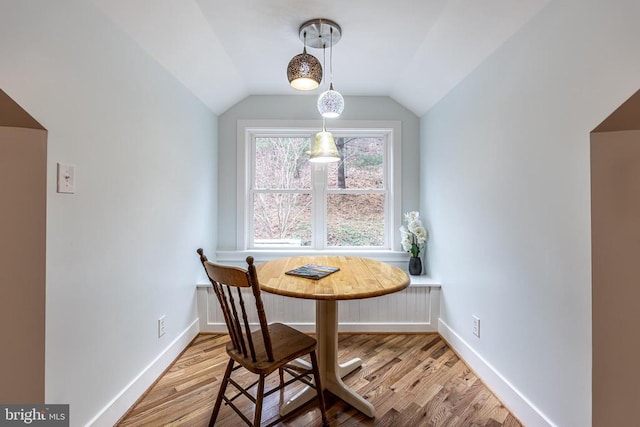 dining area featuring baseboards, lofted ceiling, wood finished floors, and radiator heating unit