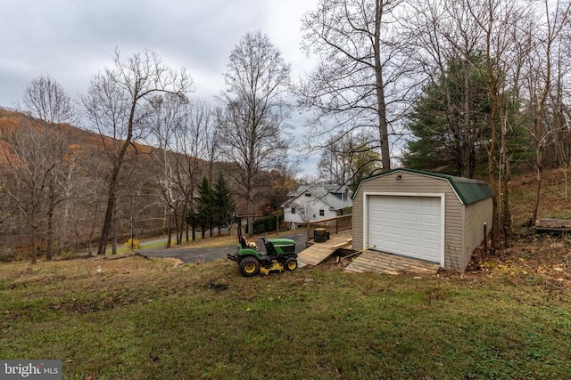 view of yard with a garage and an outbuilding
