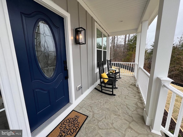 entrance to property featuring board and batten siding and covered porch