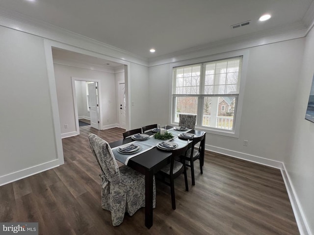 dining room with baseboards, ornamental molding, and dark wood finished floors