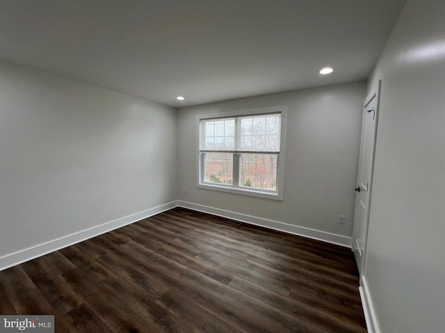 empty room featuring recessed lighting, dark wood-style floors, and baseboards