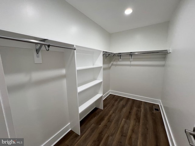 spacious closet with dark wood-style floors and visible vents