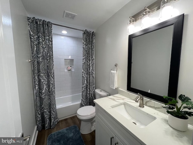 full bathroom with visible vents, toilet, shower / tub combo with curtain, wood finished floors, and vanity