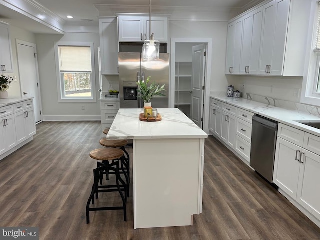 kitchen with dark wood finished floors, a kitchen island, stainless steel appliances, and crown molding