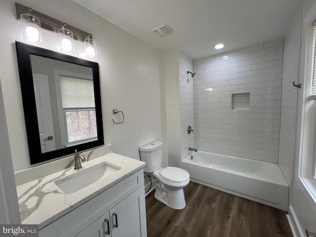 full bath featuring visible vents, toilet, shower / washtub combination, wood finished floors, and vanity