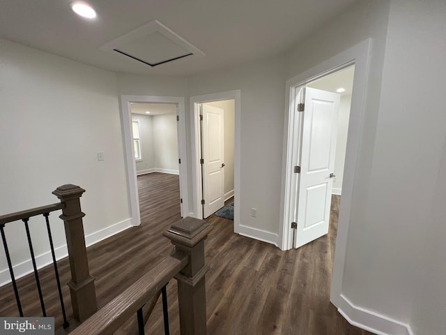 corridor with dark wood-type flooring, recessed lighting, and baseboards