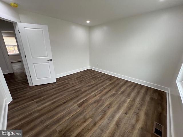 unfurnished room with recessed lighting, visible vents, baseboards, and dark wood-style floors