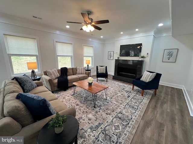 living room with visible vents, crown molding, a ceiling fan, and wood finished floors