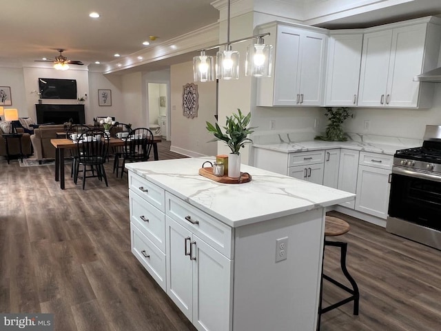 kitchen with dark wood-style floors, a ceiling fan, stainless steel gas stove, white cabinetry, and open floor plan