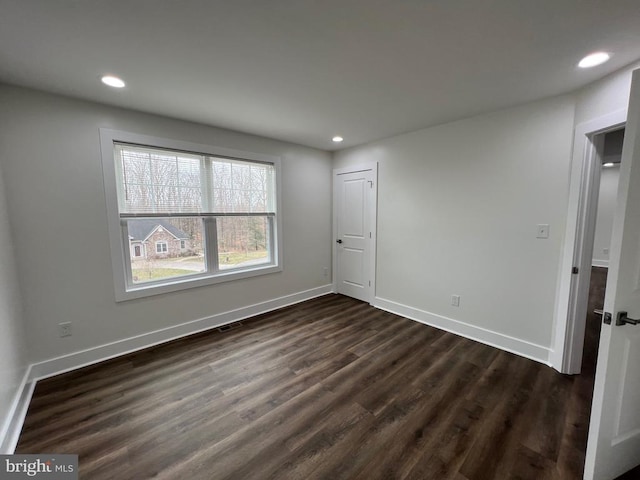 spare room featuring recessed lighting, visible vents, baseboards, and dark wood finished floors