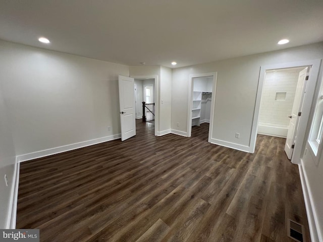 interior space featuring visible vents, a walk in closet, dark wood-style floors, recessed lighting, and baseboards