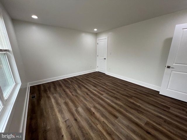 spare room featuring recessed lighting, visible vents, baseboards, and dark wood-style floors