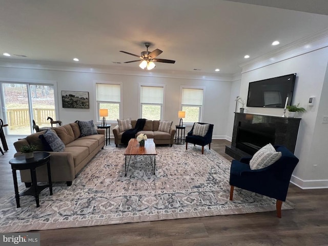 living area with ornamental molding, ceiling fan, and wood finished floors