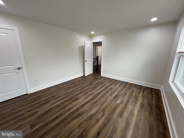 unfurnished room with dark wood finished floors, recessed lighting, and baseboards