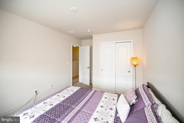 carpeted bedroom featuring a closet and baseboards