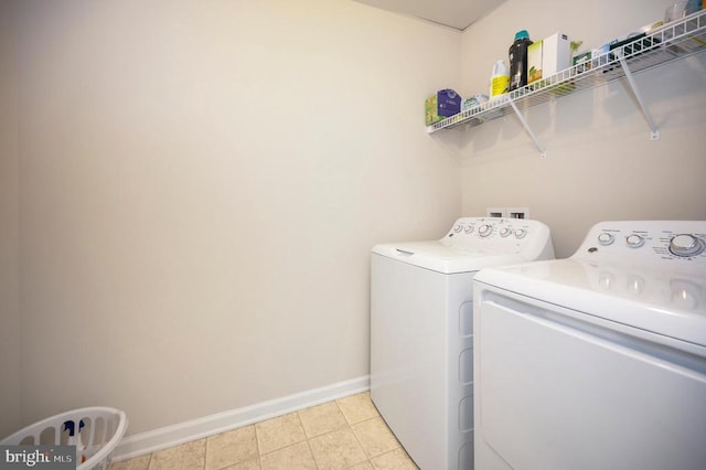 clothes washing area featuring laundry area, separate washer and dryer, and baseboards