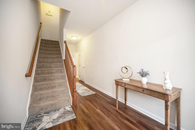 staircase featuring baseboards and wood finished floors