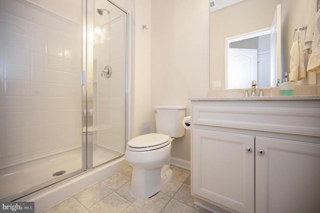 bathroom with baseboards, toilet, a stall shower, and vanity