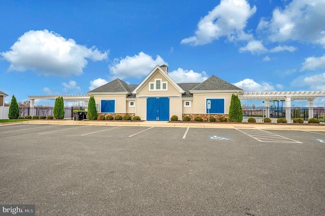 view of property with uncovered parking and fence