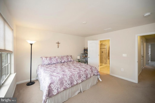 carpeted bedroom featuring ensuite bathroom and baseboards