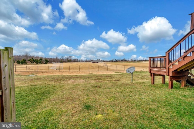 view of yard featuring stairway, a rural view, and fence