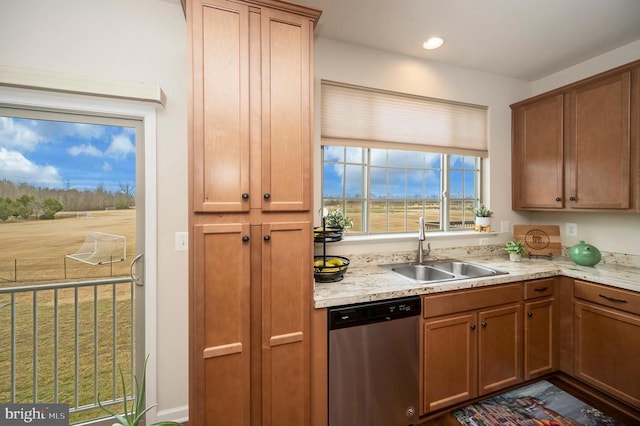 kitchen with dishwasher, brown cabinetry, and a sink